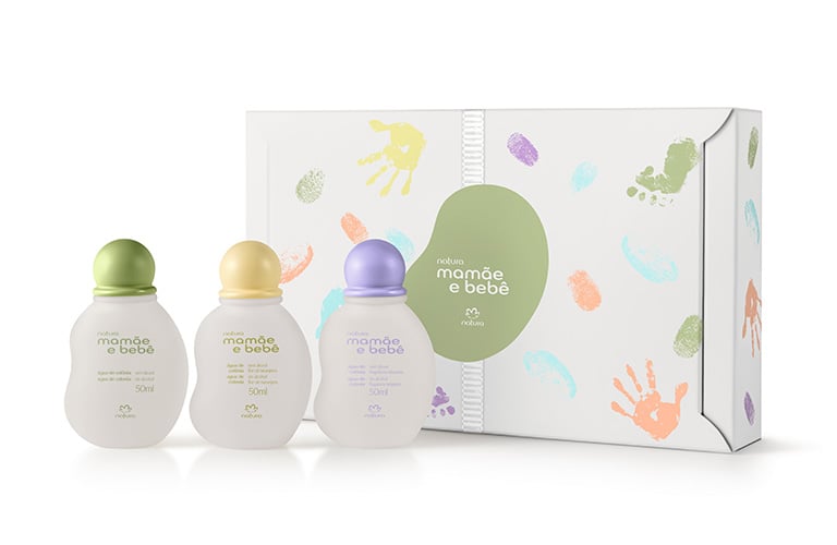 Imagen de un set de productos mamá y bebé que incluye tres frascos con tapas de colores: verde, amarillo y morado. El empaque presenta huellas de manos y pies en colores suaves.